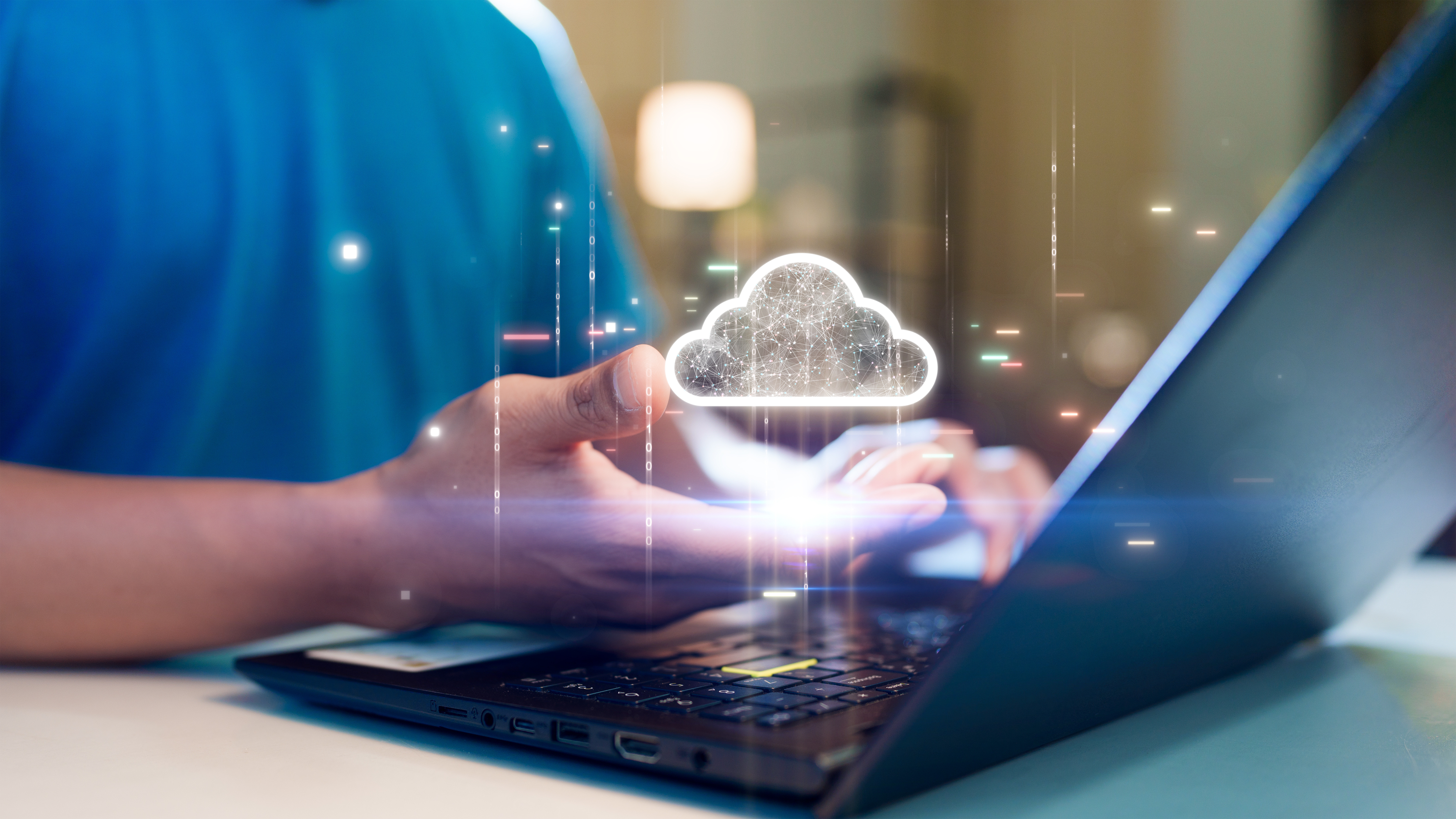 Image représentant un homme, un ordinateur portable et un cloud scintillant dans la main de cet homme.